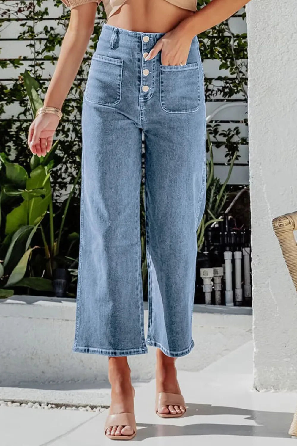 Light blue button fly cropped wide-leg jeans from Trendsi, showing high-waisted fit and relaxed style with visible stitching.