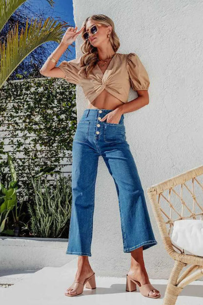 Light blue button fly cropped wide-leg jeans by Trendsi, showing relaxed fit and high-rise style with visible denim texture.