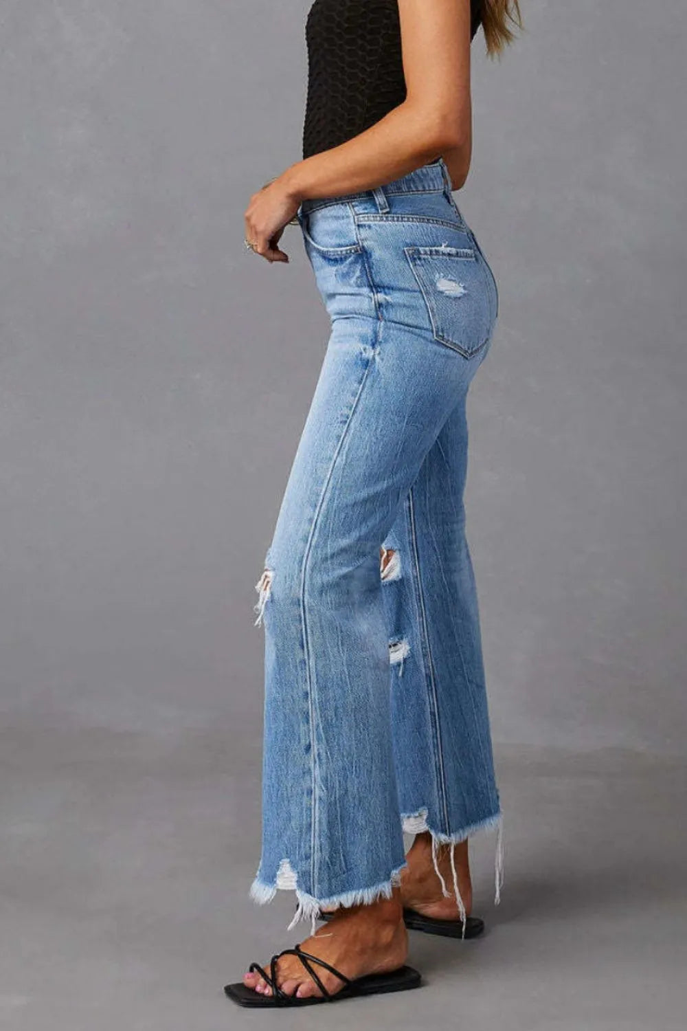 Light blue distressed raw hem jeans with front and back pockets from Trendsi, casual denim pants for everyday wear.
