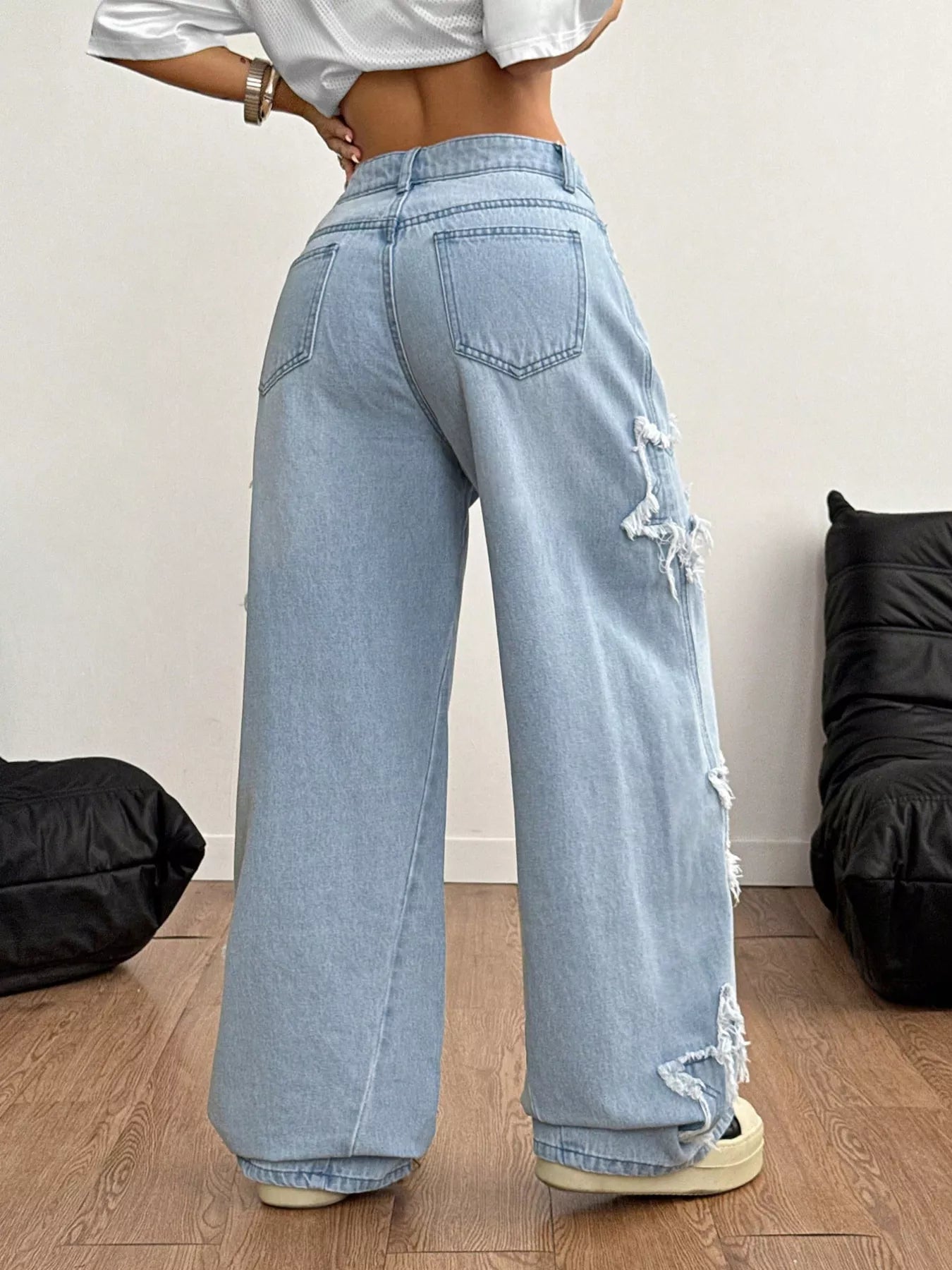 Light blue distressed star patch wide-leg jeans from Trendsi, featuring a relaxed fit and trendy distressed detailing.