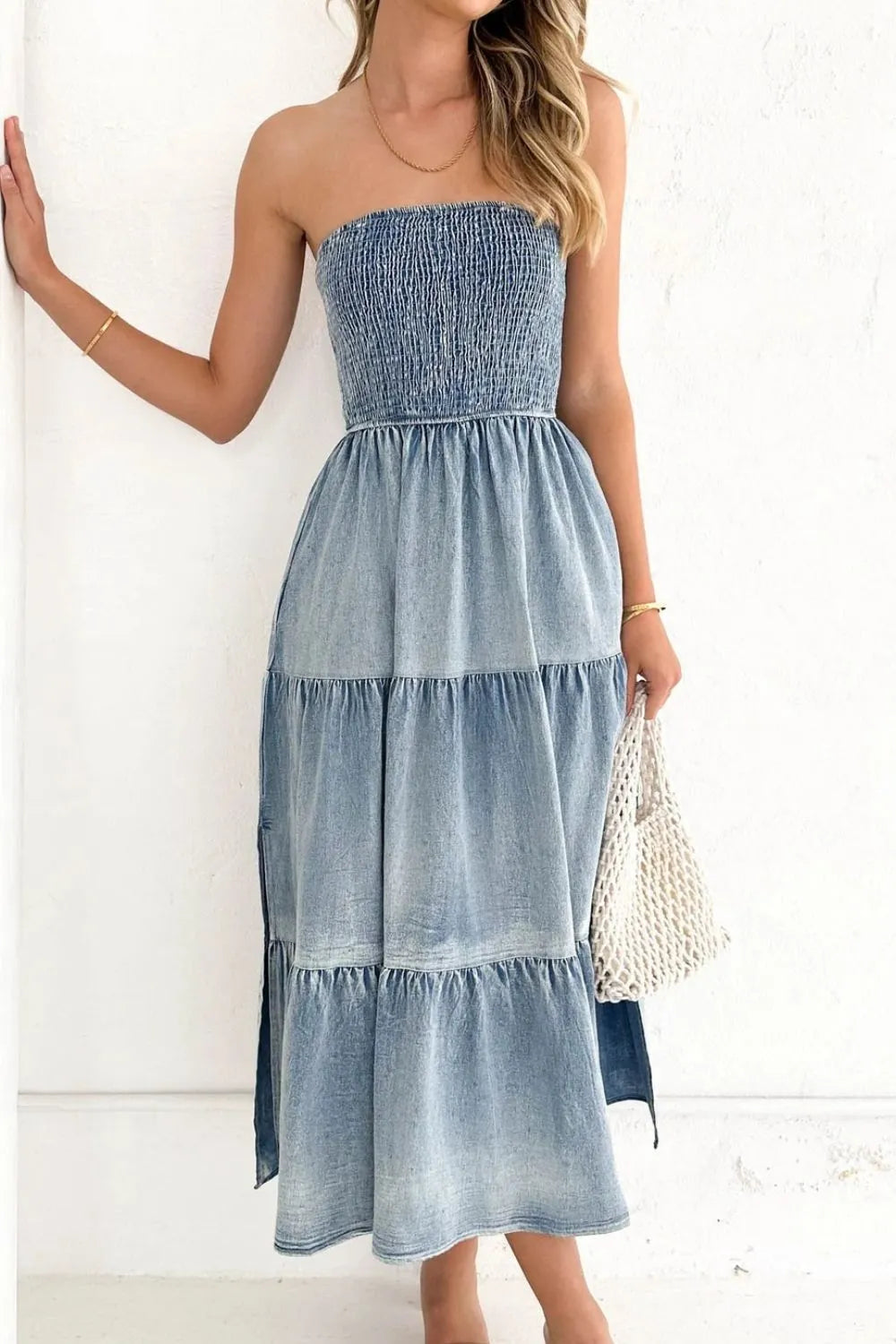 Light blue smocked tube denim dress with slit and tiered design, styled by Trendsi.