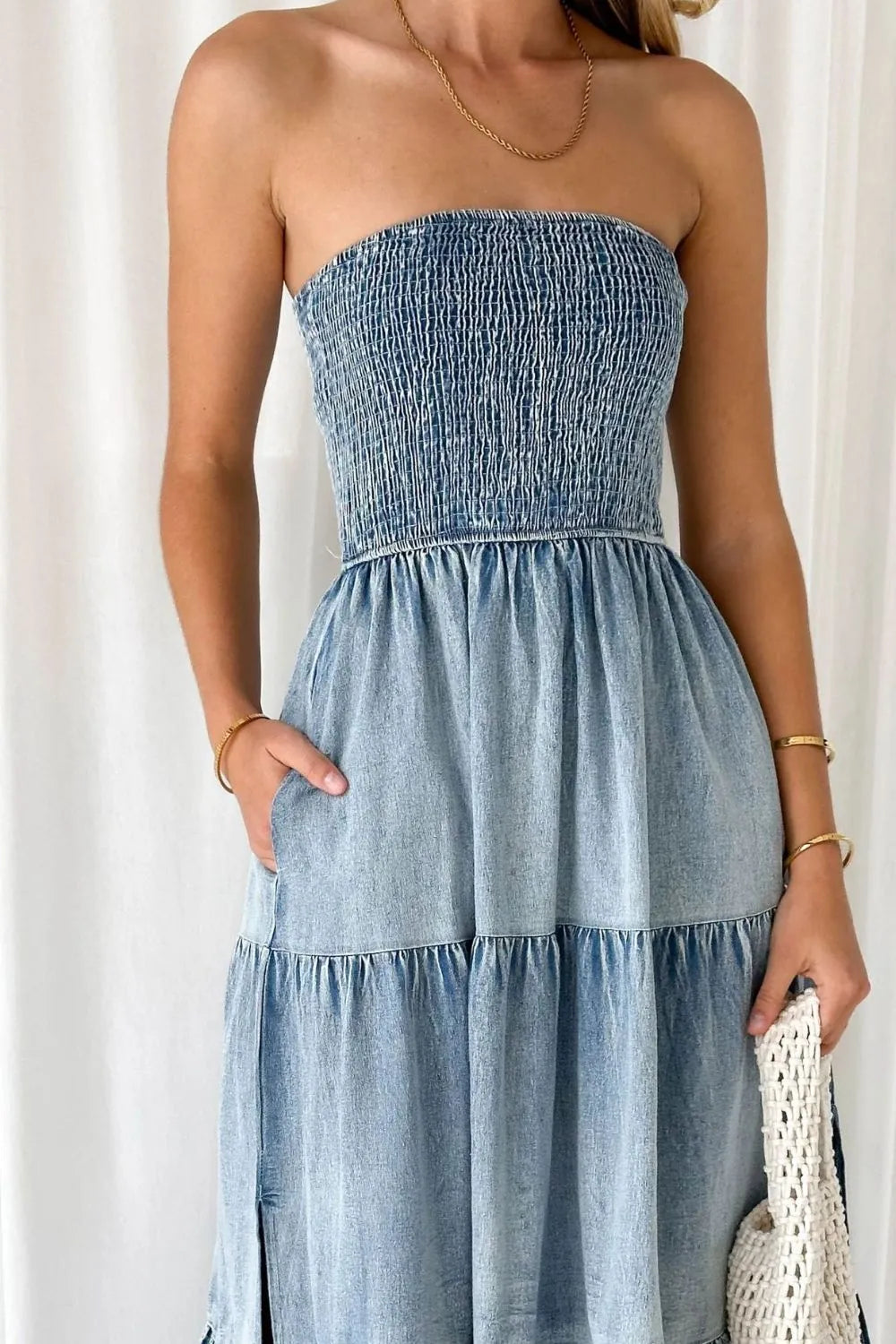 Light blue smocked tube denim dress with slit and tiered design by Trendsi, displayed on a model.