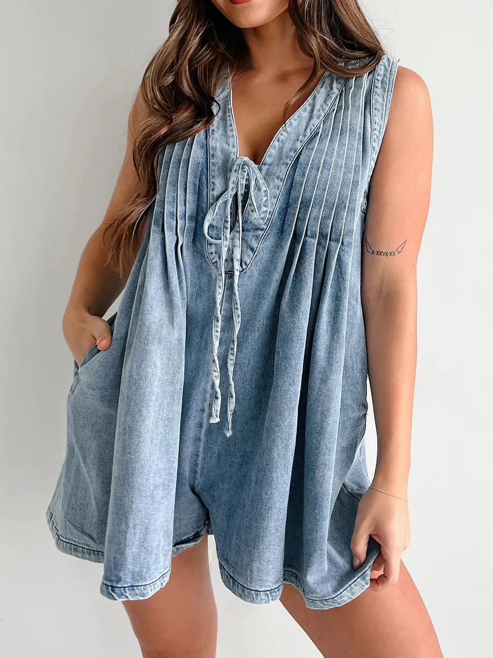 Light blue tied romper with pockets from Trendsi, featuring a casual sleeveless design and front pockets for a relaxed look.