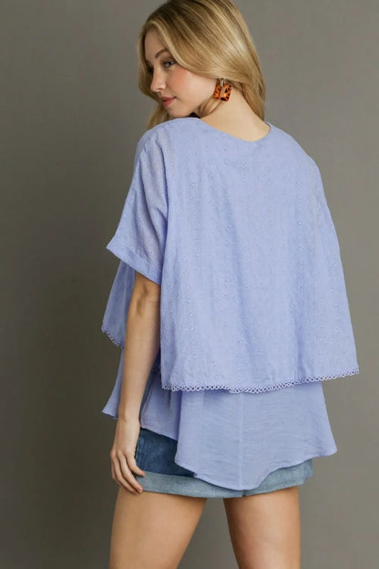 Light blue Umgee plus size eyelet layered short sleeve blouse with eyelet details and relaxed fit, styled for a casual look.
