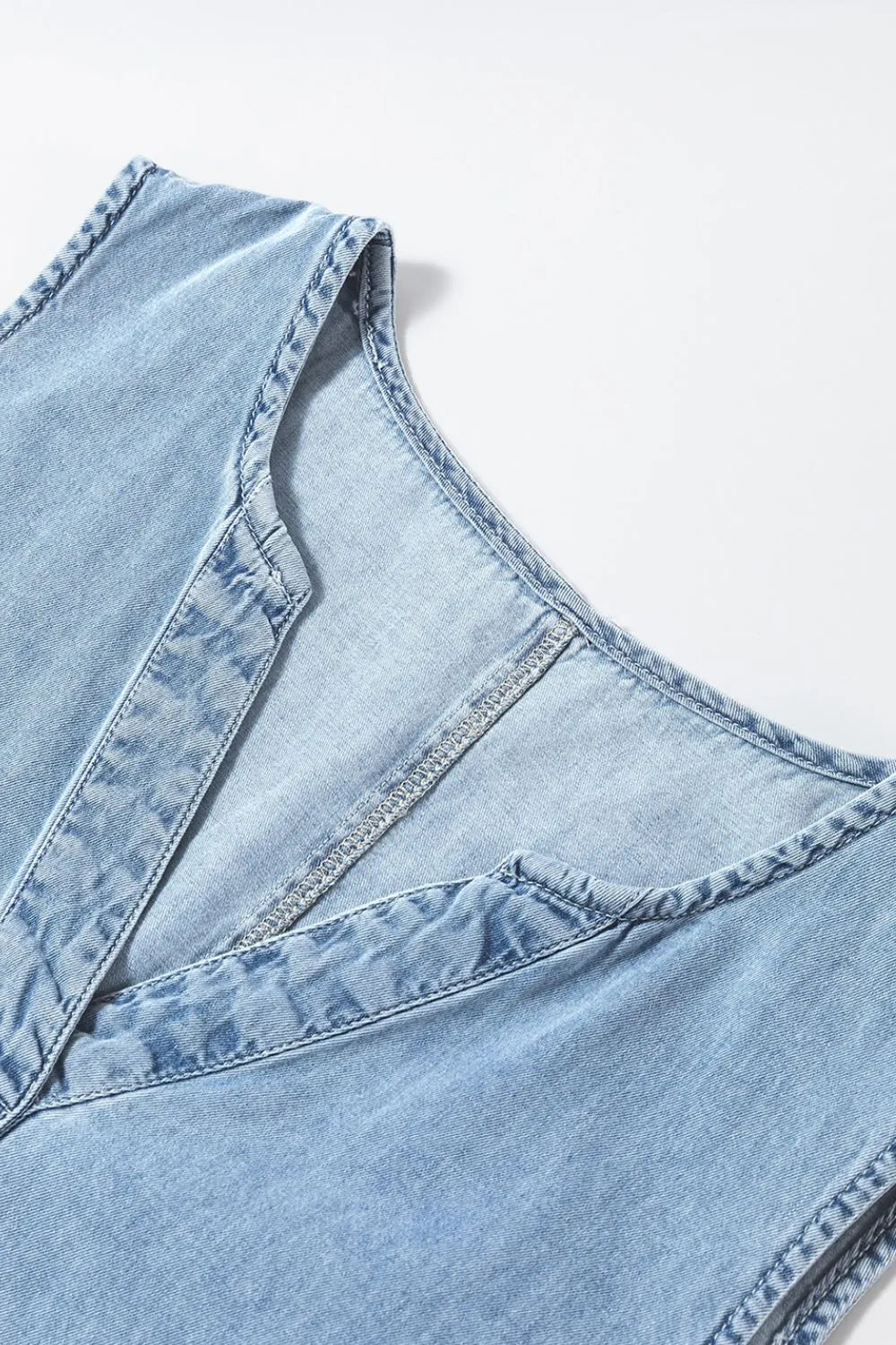 Light blue sleeveless mini denim dress with notched neckline by Trendsi, showcasing a casual, stylish fit.