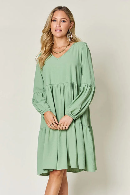 Light green Trendsi double take full-size V-neck balloon sleeve tiered dress with pockets, showcasing a stylish, flowy design.