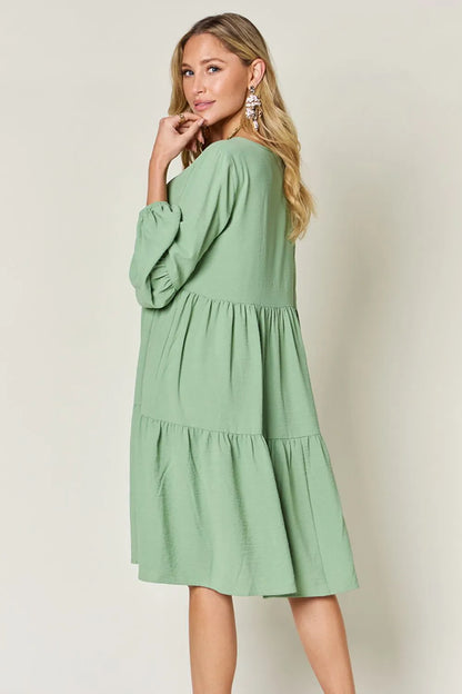 Light green double take full-size V-neck balloon sleeve tiered dress with pockets by Trendsi, shown on a model.