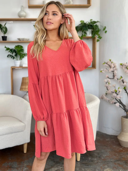 Light green Trendsi double take full-size v-neck balloon sleeve tiered dress with pockets on a model.
