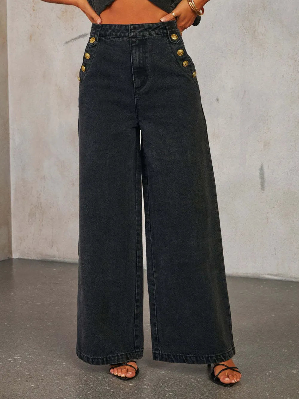 Light wash high-rise wide-leg jeans with button decor by Trendsi, displayed on a model showing fit and style.