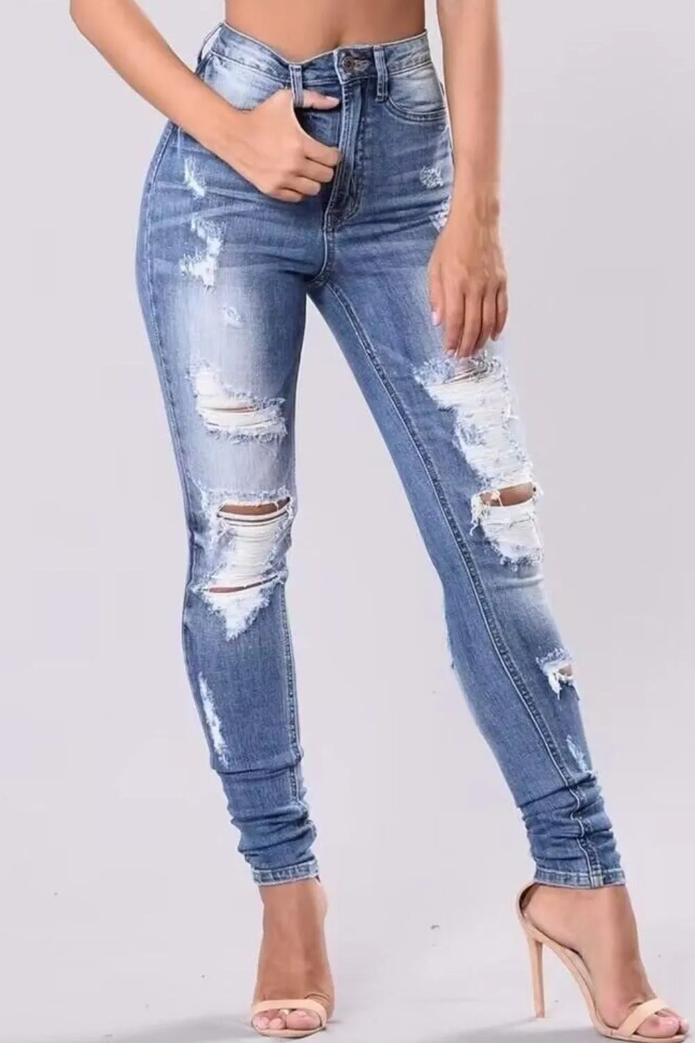 Plus size full-length distressed skinny jeans by Trendsi, showing fit and ripped details on a model.