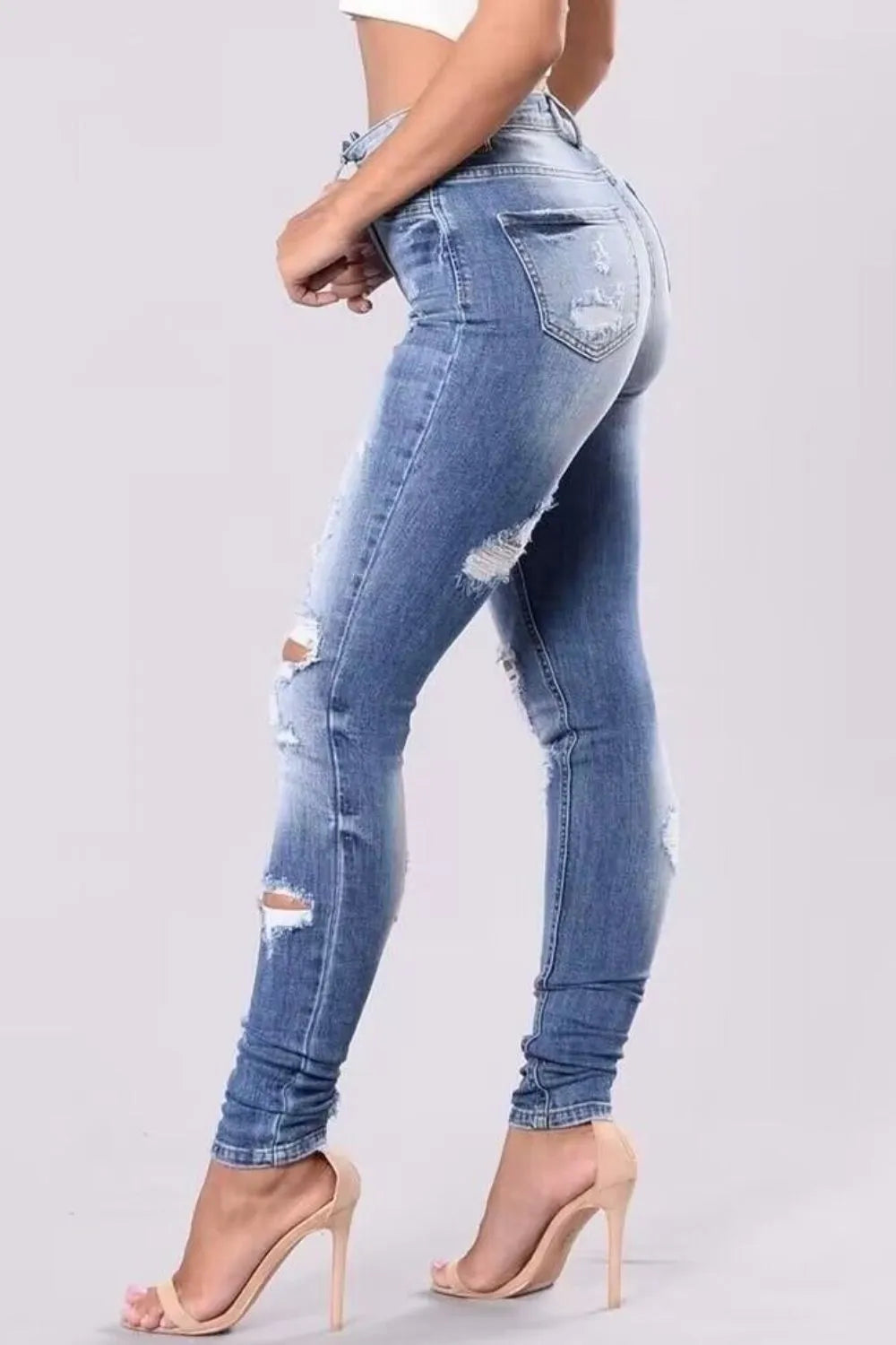 Plus size full length distressed skinny jeans from Trendsi, showcasing a fitted, ripped style with a casual, trendy look.