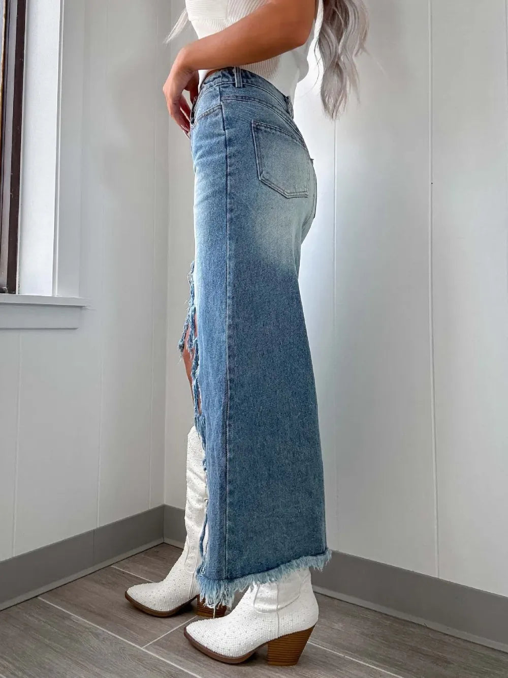Light blue high-waist raw hem asymmetry denim skirt by Trendsi, showcasing distressed details and uneven hemline.