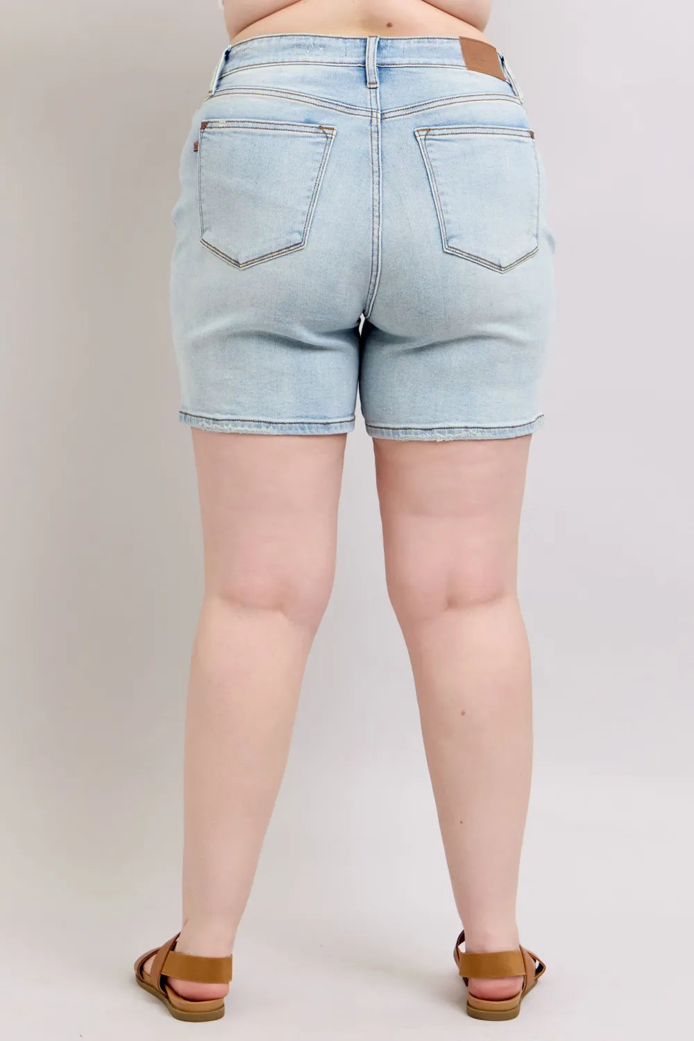 Light blue Judy Blue denim shorts with two buttons and pockets, designed for plus size, featuring a casual fit and stylish details.