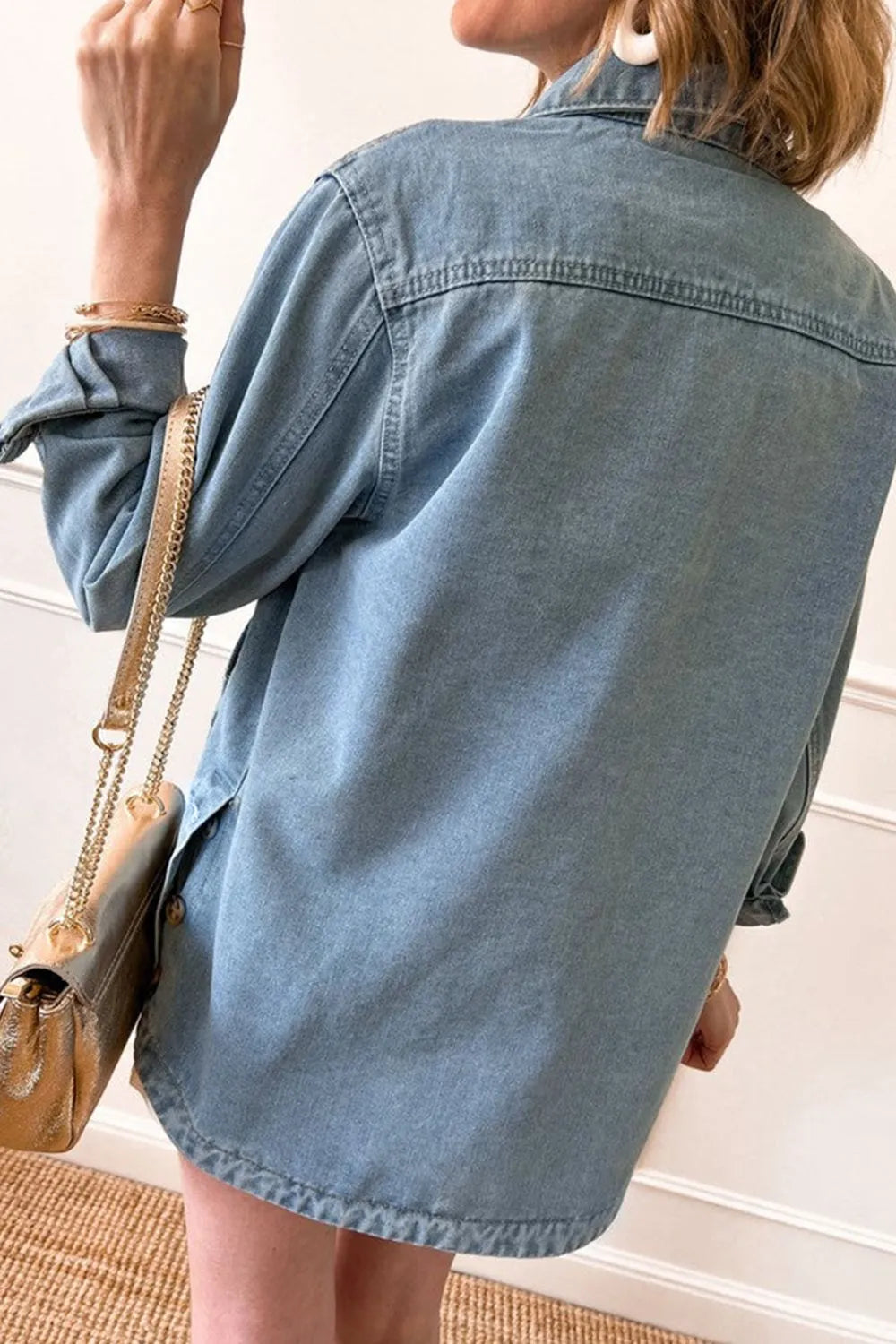 Light wash pocketed button-up long sleeve denim jacket from Trendsi, featuring classic style and front chest pockets.