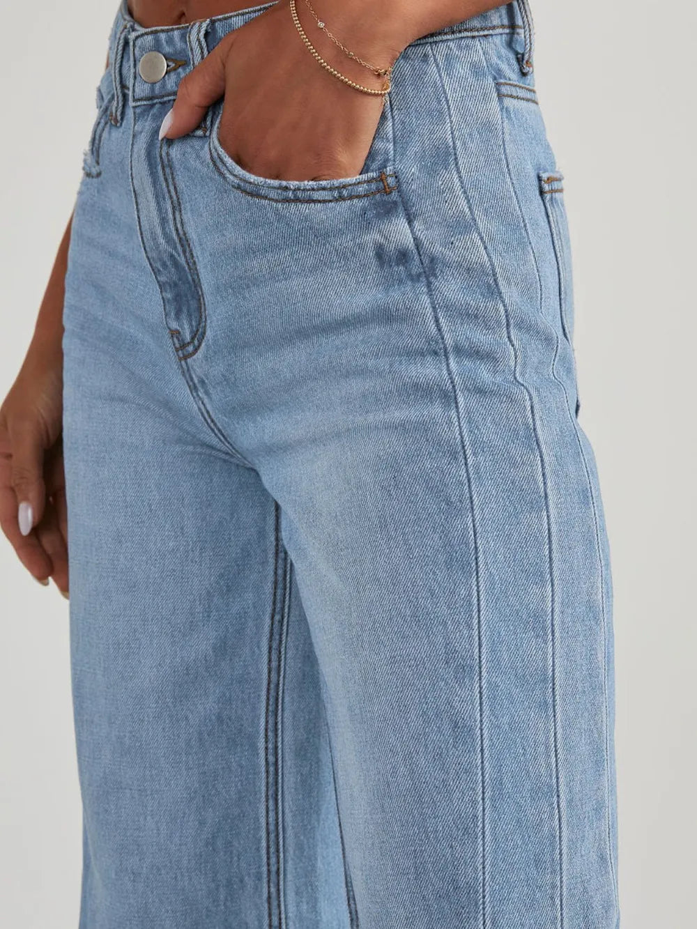 Light wash raw hem wide-leg jeans with pockets from Trendsi, showcasing a relaxed fit and casual style.