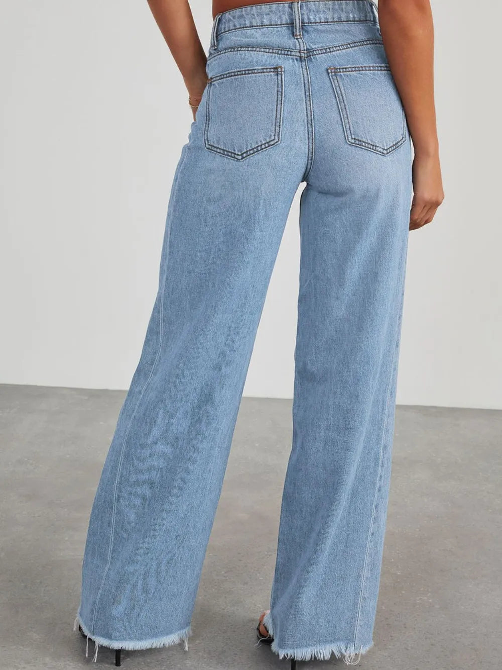 Light wash raw hem wide-leg jeans with pockets from Trendsi, featuring a relaxed fit and casual style.