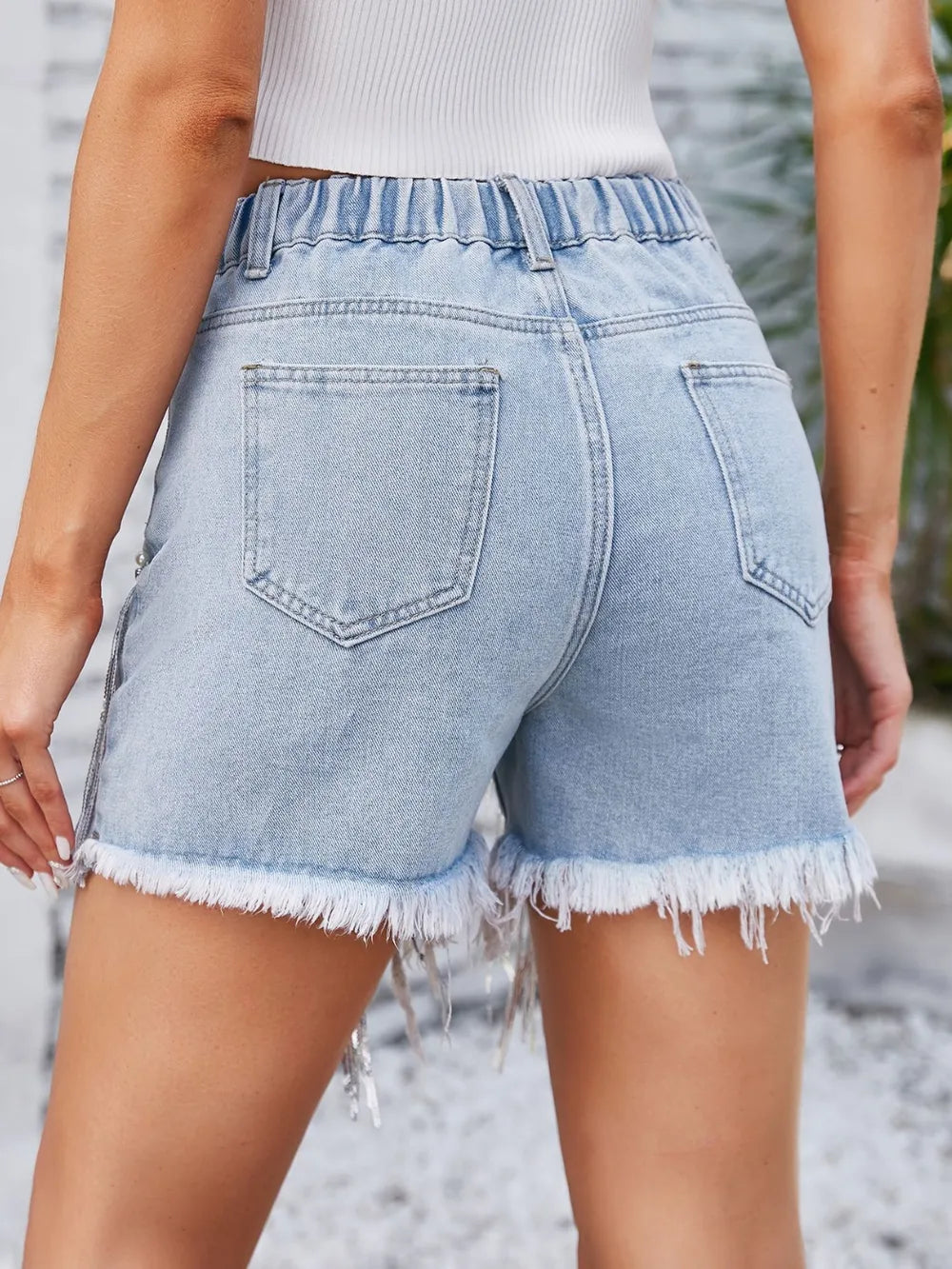 Light wash distressed denim shorts with pearl trim and pockets, trendy fashion from Trendsi.