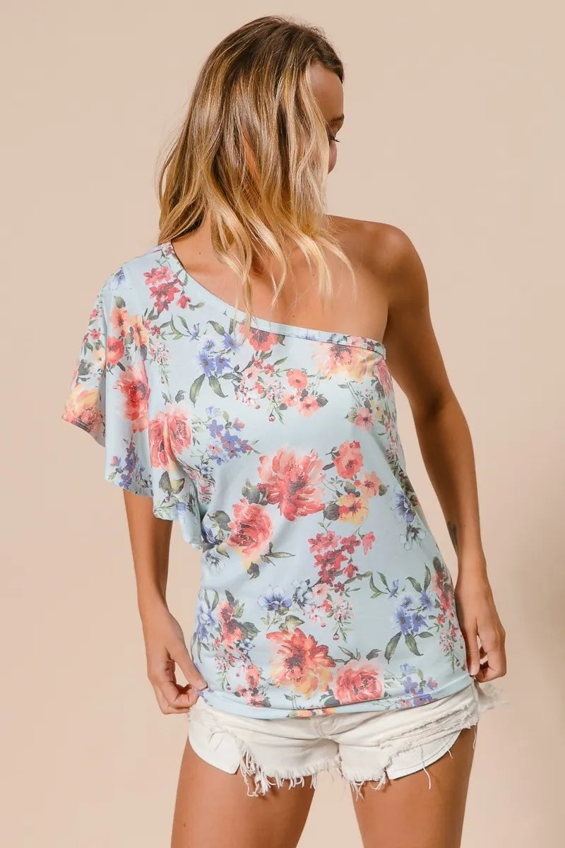 Light blue BiBi floral printed jersey knit ruffle sleeve top by Trendsi, showcasing ruffled sleeves and a vibrant floral pattern.