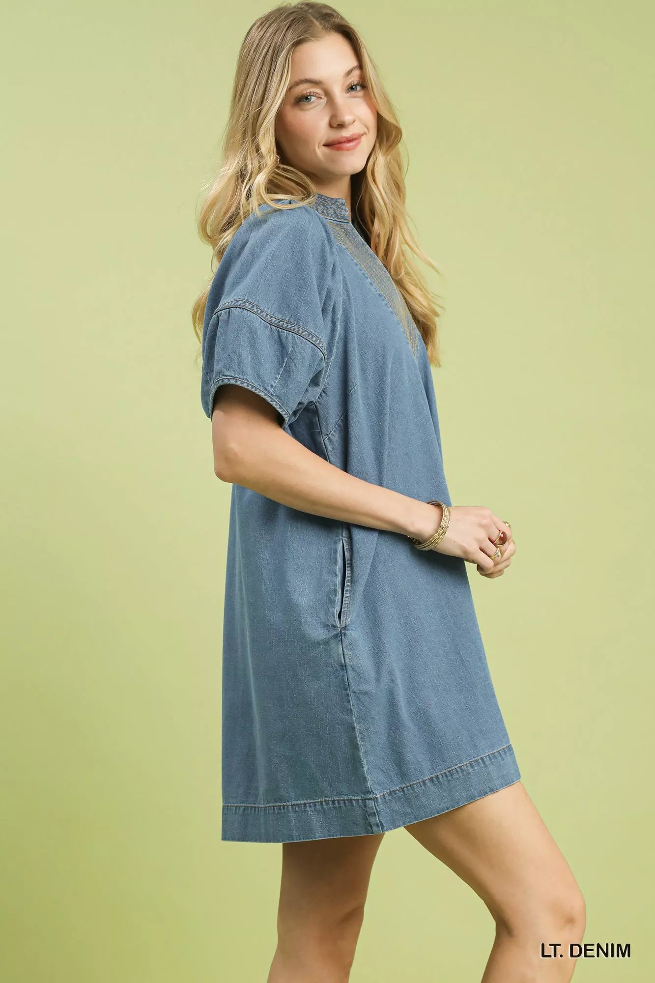 Light blue Umgee denim mini dress with contrast thread detailing, sleeveless design, and fitted silhouette.