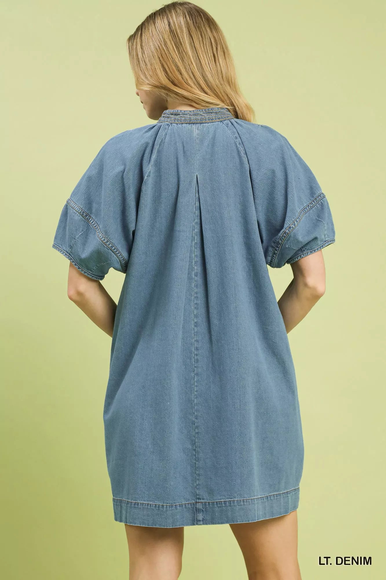 Umgee denim mini dress with contrast thread, featuring a fitted silhouette and stylish design, displayed on a hanger.