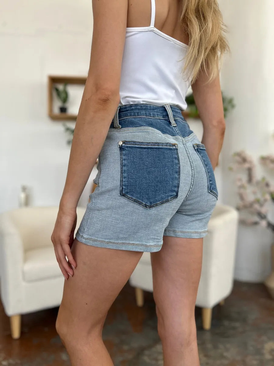 Full view of Judy Blue full size color block denim shorts with blue, white, and black panels, casual fit, and classic denim texture.
