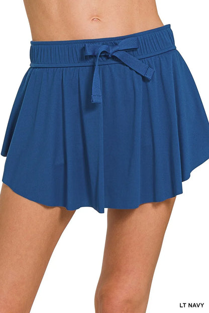 Navy Zenana tennis skirt by Trendsi with ruffle hem and hidden inner pockets, made from lightweight athletic fabric.