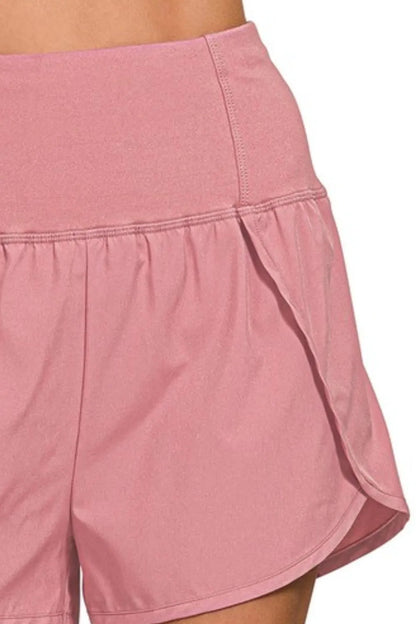 Zenana high-waisted running shorts with zippered back pocket and side pockets, in light rose color, designed for active wear.