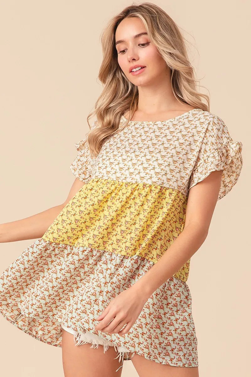 Trendsi BiBi floral printed woven color block and tiered top in yellow and sage, showcasing vibrant pattern and layered design.