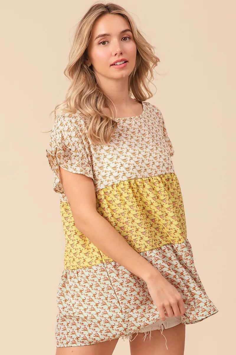 Trendsi BiBi floral printed woven color block and tiered top in yellow and sage, featuring a flowing, layered design.