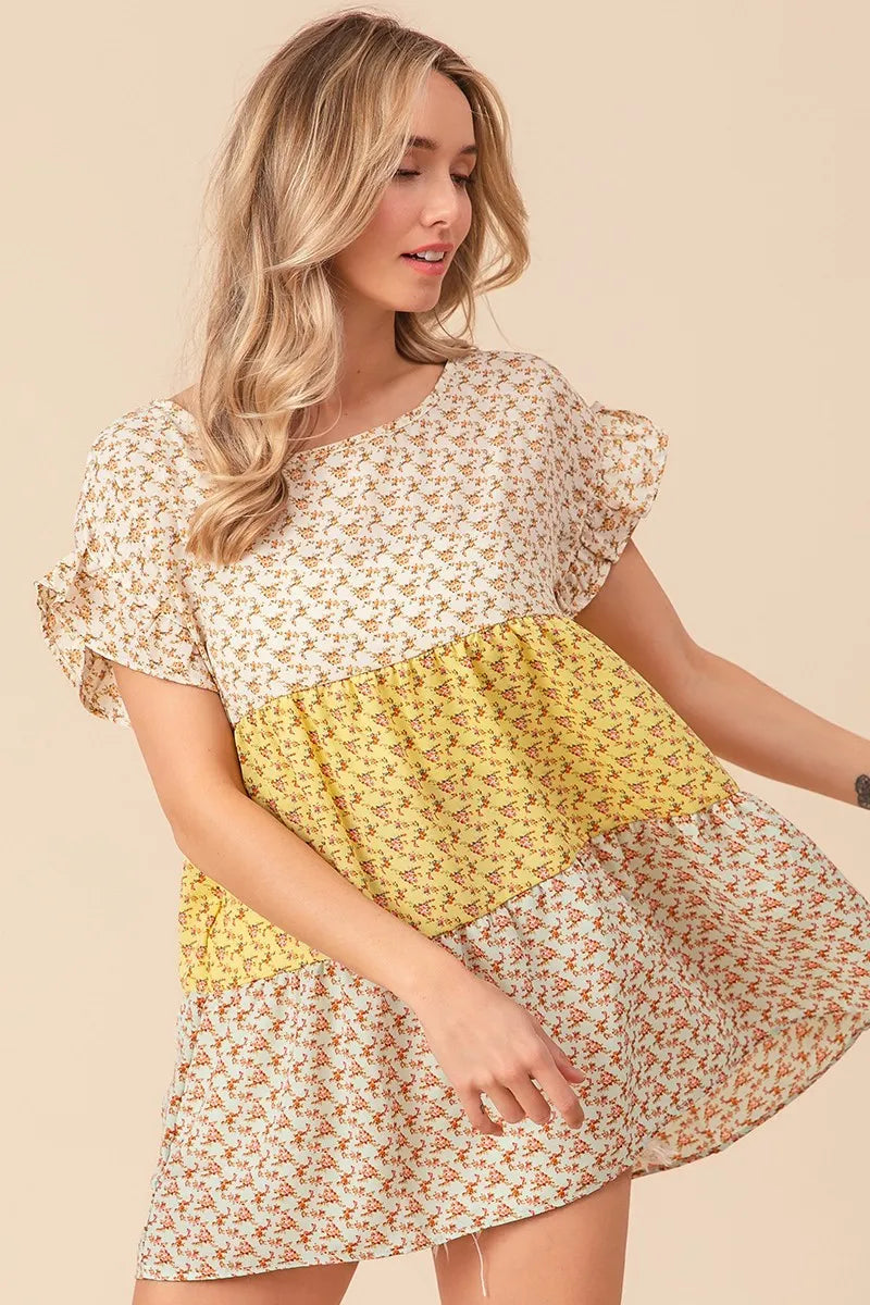 Trendsi BiBi floral printed woven color block and tiered top in yellow and sage, showcasing its layered design and vibrant pattern.