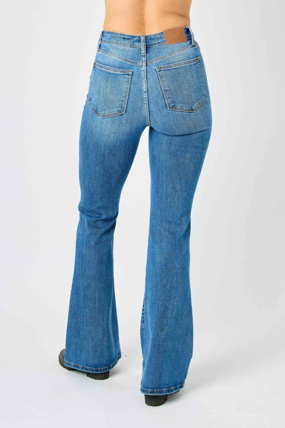 Plus size Judy Blue high-waisted classic flare jeans with a full-length fit, shown on a model in natural lighting.