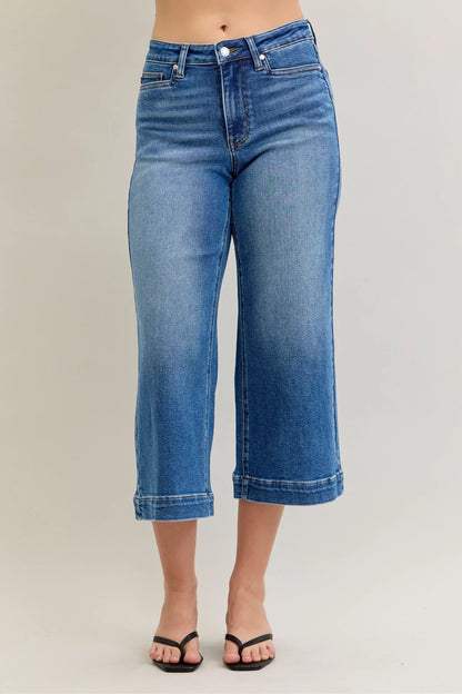 Mid-rise Judy Blue crop wide-leg jeans from Trendsi, shown on a model, featuring a relaxed fit and classic denim wash.
