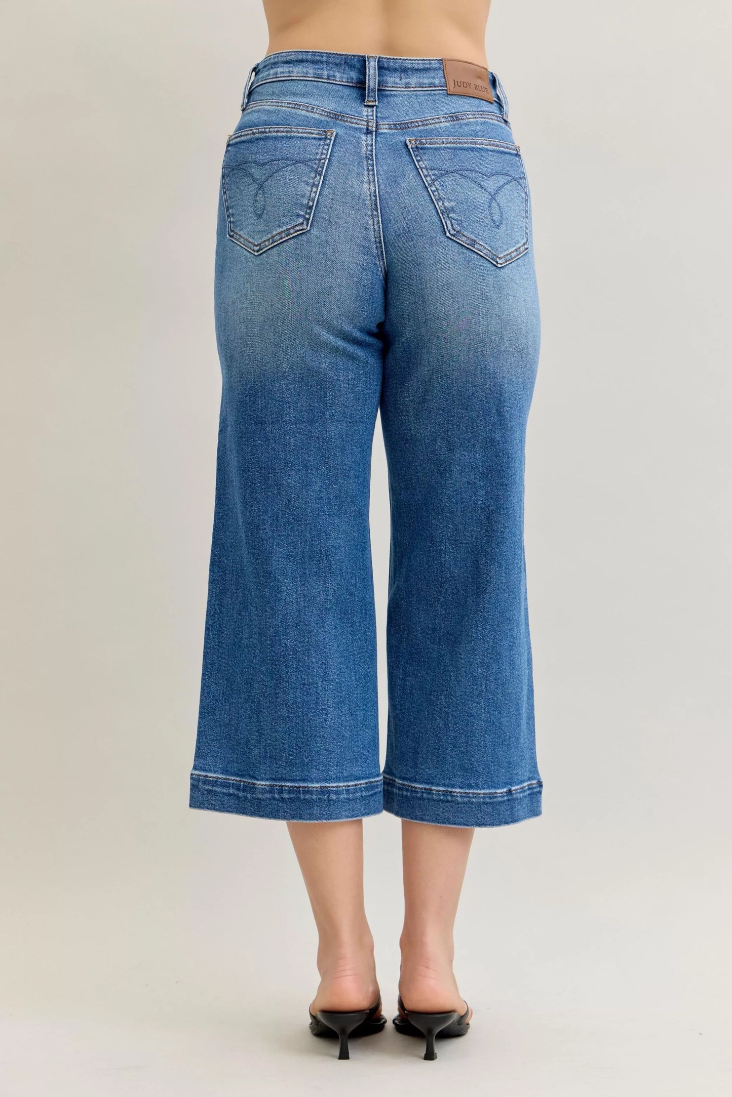 Mid-rise Judy Blue crop wide-leg jeans with a relaxed fit, styled with a casual, trendy look.