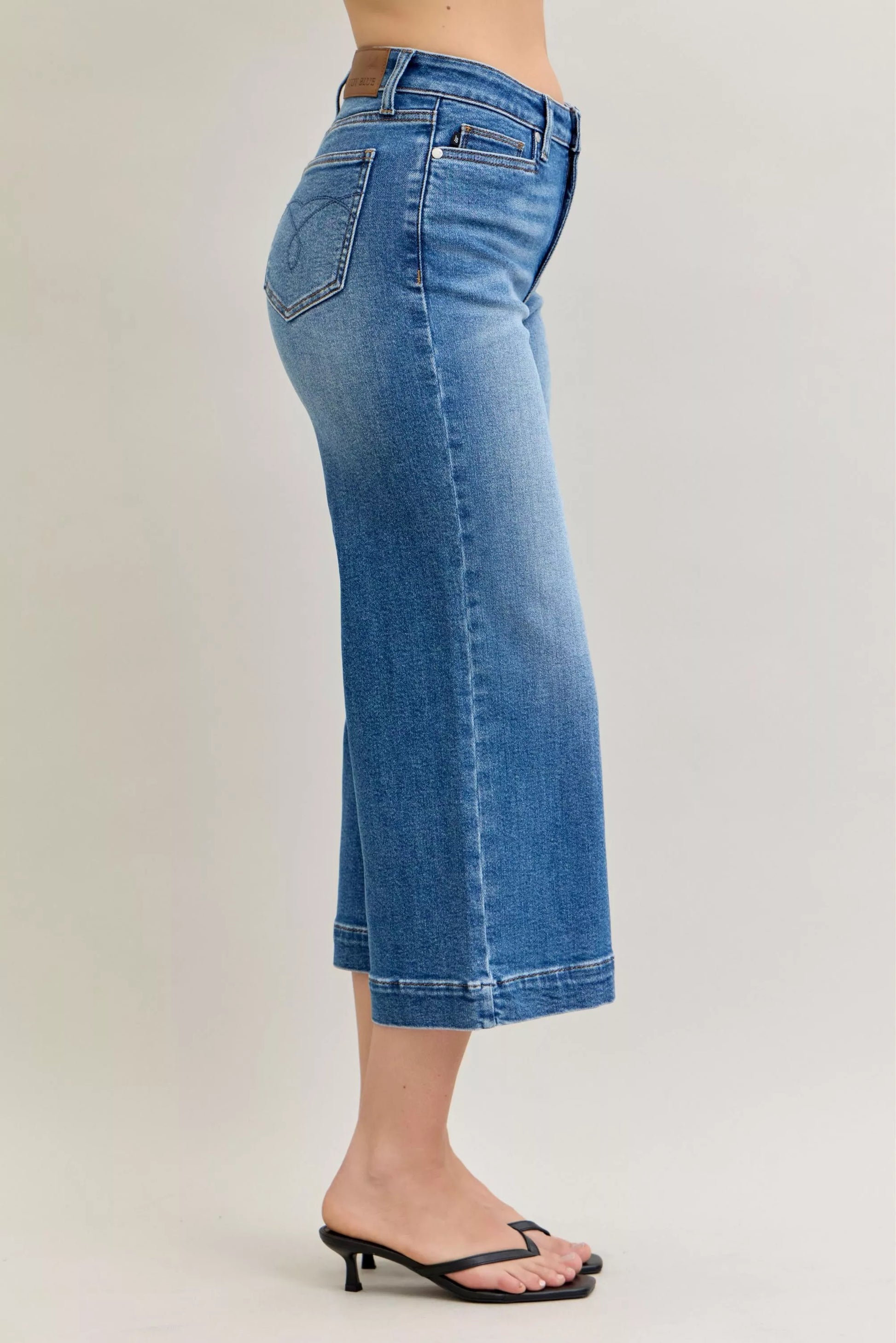 Light blue Judy Blue mid-rise crop wide-leg jeans with classic five-pocket design, styled for a casual look.