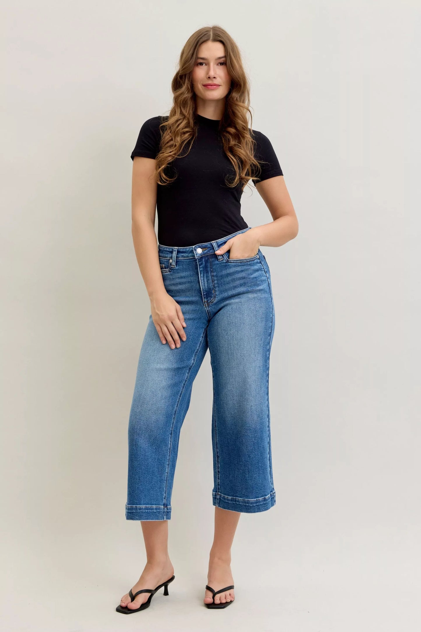 Light blue Judy Blue mid-rise crop wide-leg jeans with front pockets and distressed details, styled on a model.