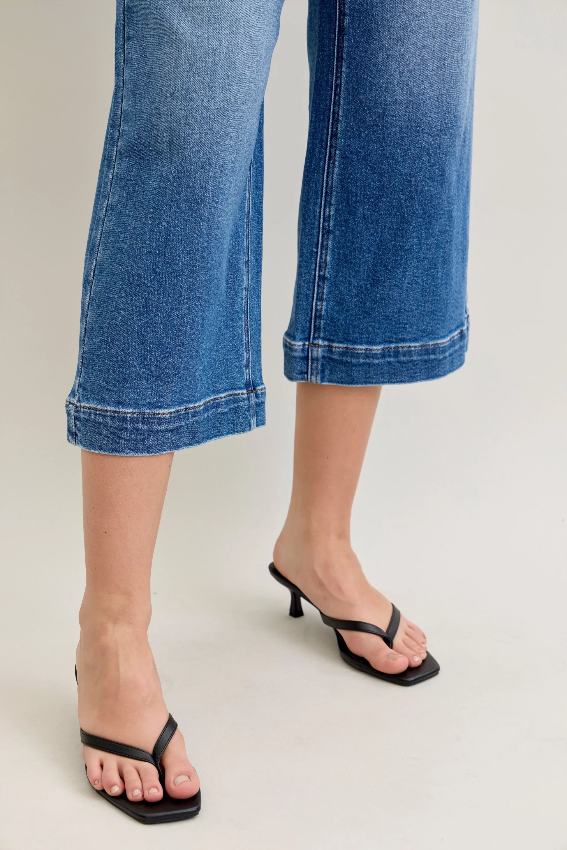 Mid-rise Judy Blue crop wide-leg jeans featuring a relaxed fit and classic denim wash, displayed on a white background.