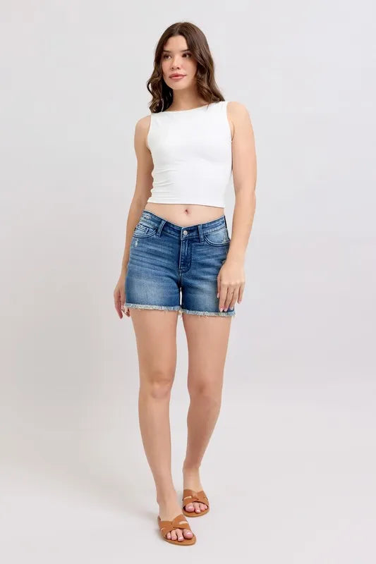 Plus size Judy Blue denim shorts with V-front design and shield pockets, shown on a full-size model.