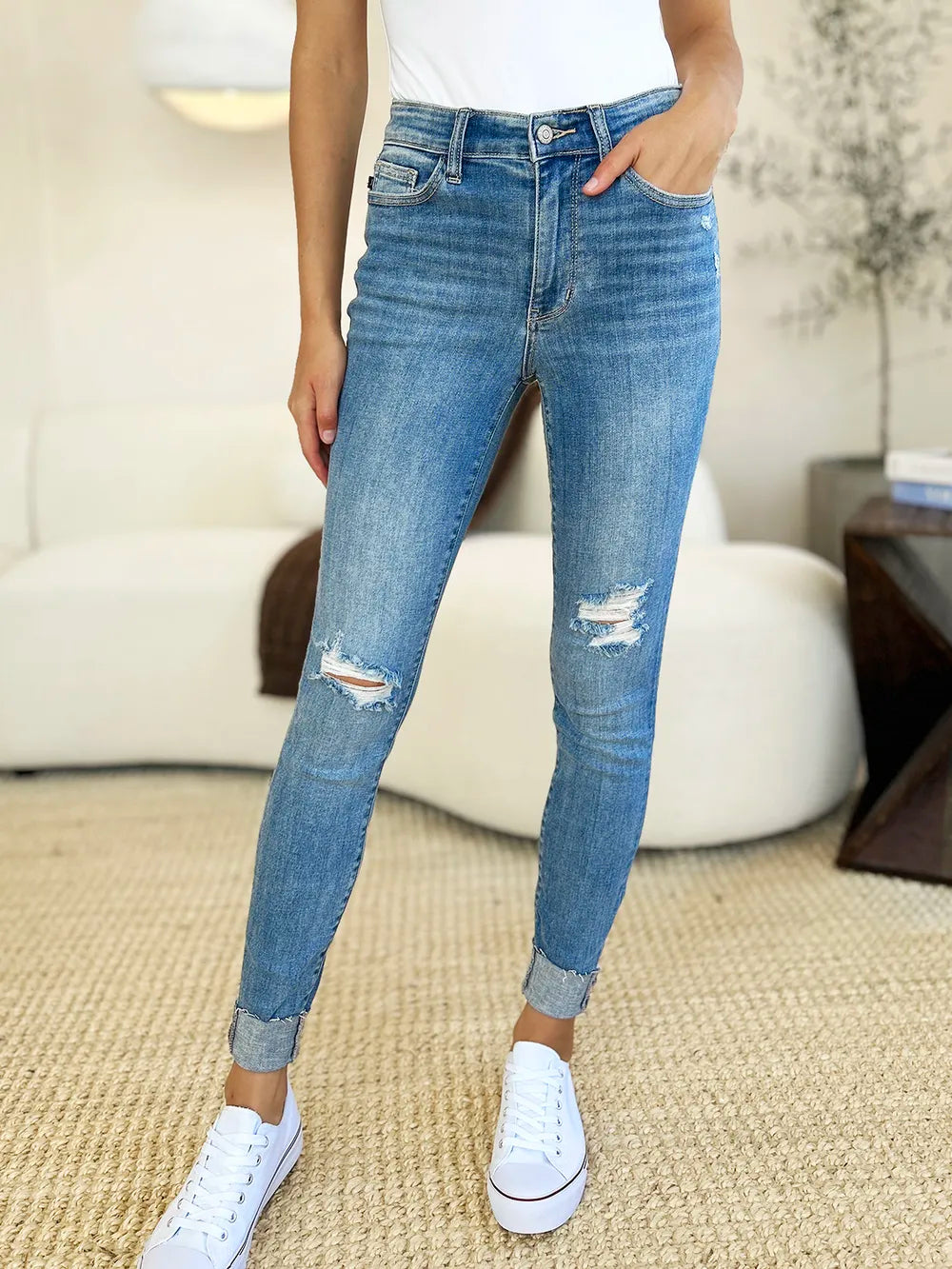 Judy Blue full-size mid-rise destroy and cuff skinny jeans, denim with distressed details and rolled cuffs, on a model.