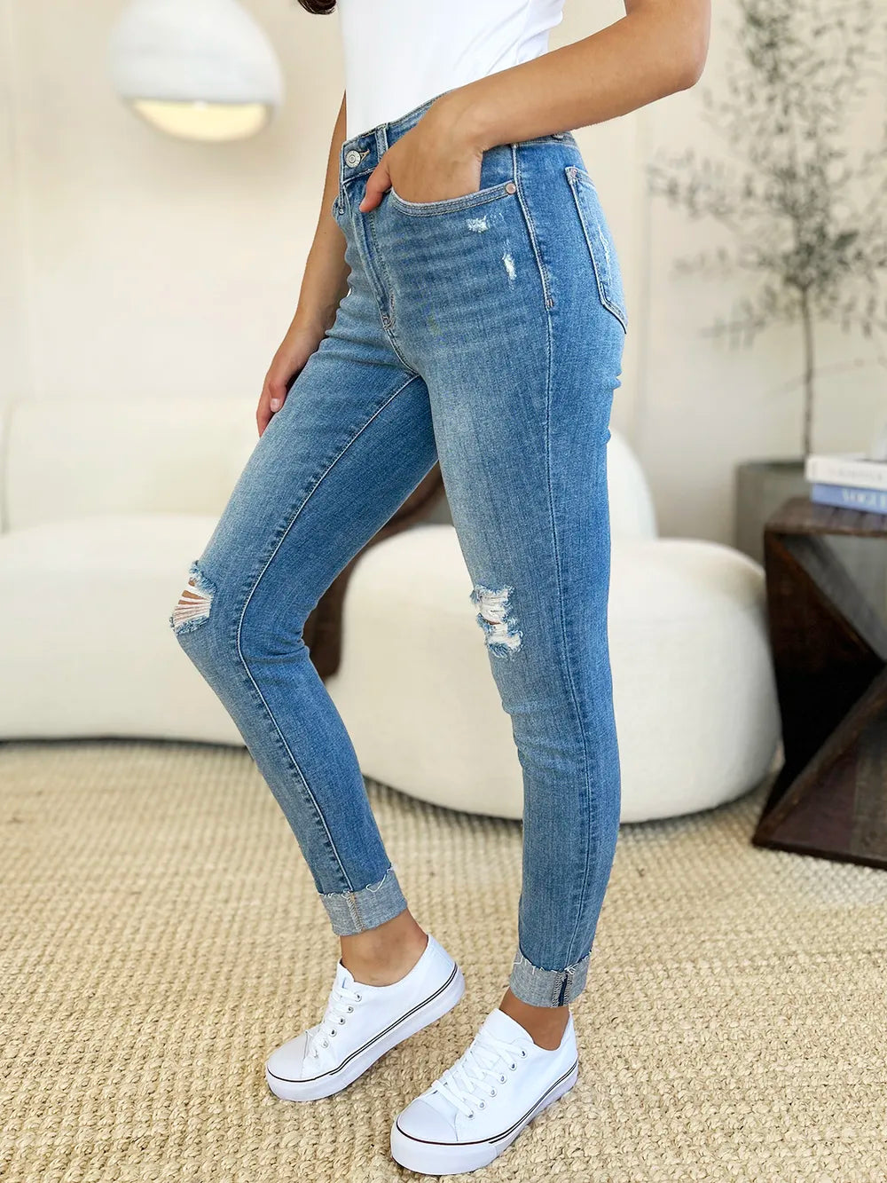 Judy Blue full-size mid-rise destroy and cuff skinny jeans with distressed details and rolled cuffs on a model.