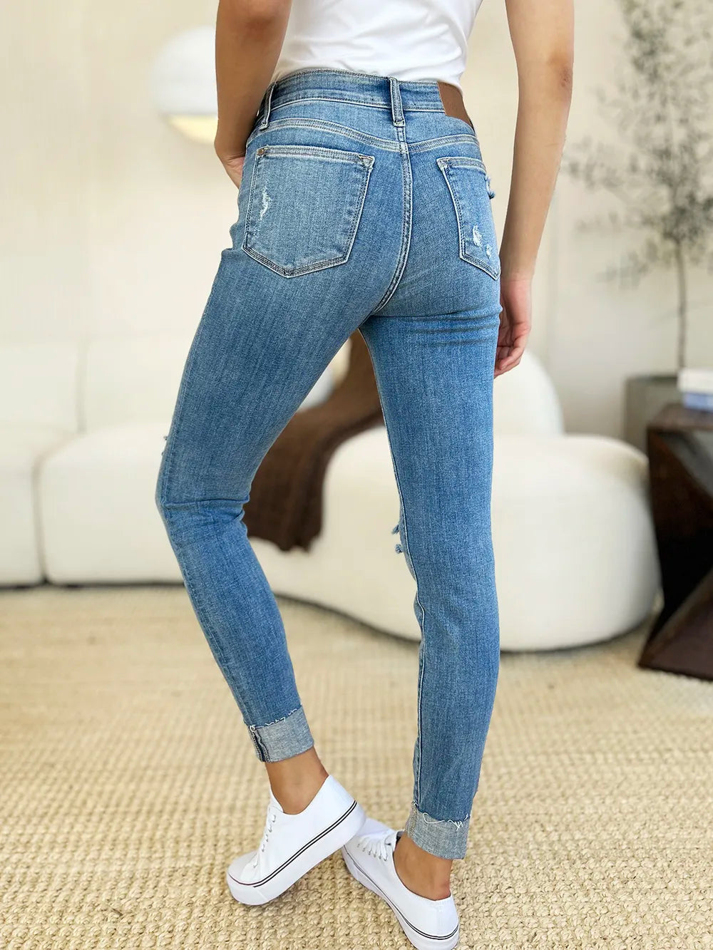 Judy Blue full-size mid-rise skinny jeans with distressed details and rolled cuffs, showcasing a slim fit and trendy style.