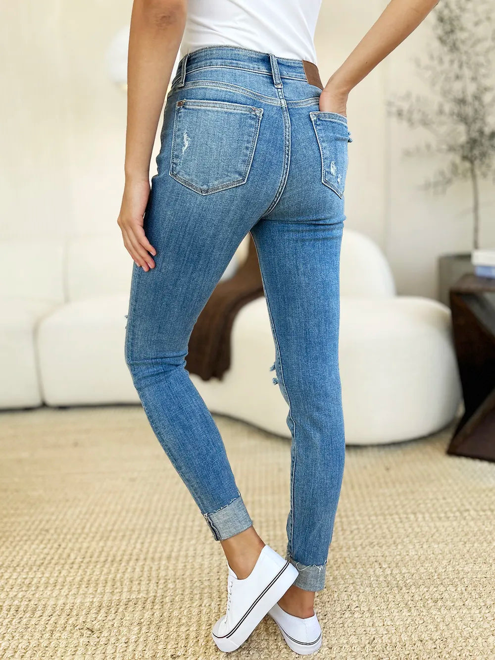 Judy Blue full-size mid-rise skinny jeans with distressed details and cuffed hems, styled on a model.