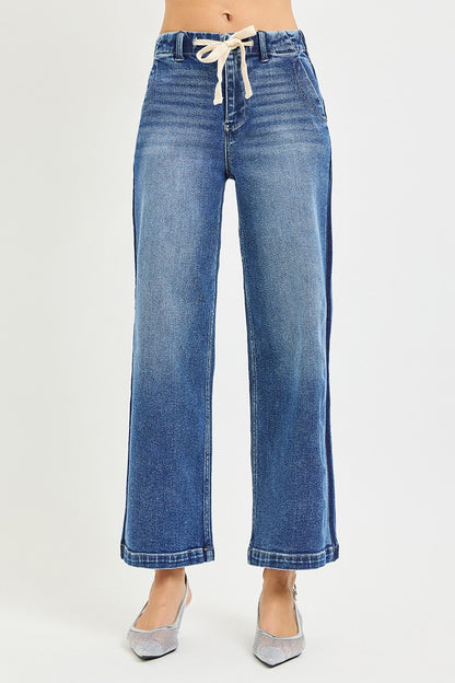Risen high-rise cropped wide jeans with elastic band and distressed details, styled with a casual top and sneakers.