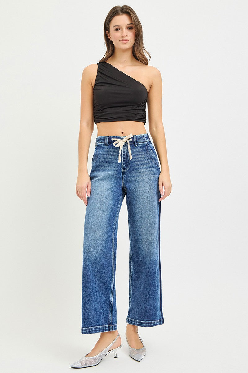 Risen high-rise cropped wide jeans with elastic waistband, featuring a relaxed fit and trendy style in denim fabric.