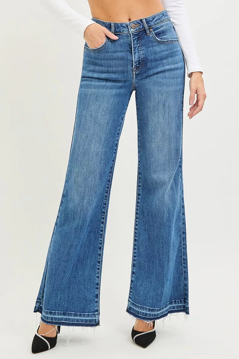 Risen high-rise wide-leg jeans with a released hem, styled casually, featuring a denim fabric and relaxed fit.