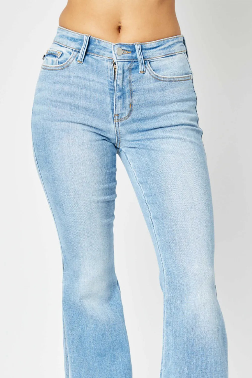 Medium shot of Judy Blue mid-rise flare jeans with raw hem and slit detail, showcasing their trendy, stylish fit.