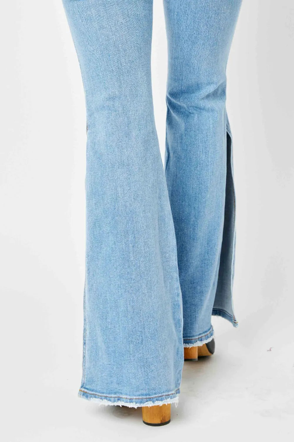 Judy Blue full-size mid-rise flare jeans with raw hem and slit detail, stylish denim pants from Trendsi.