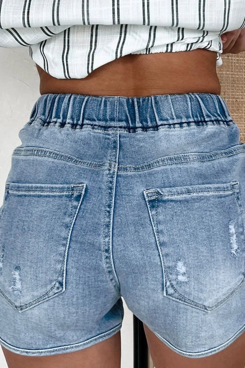 Drawstring high waist distressed denim shorts by Trendsi, featuring a casual fit, frayed edges, and a trendy distressed design.