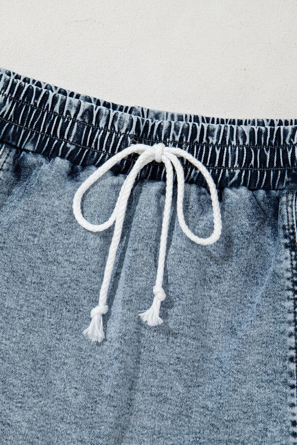 Medium-length drawstring high waist denim shorts with front pockets, styled for casual wear by Trendsi.
