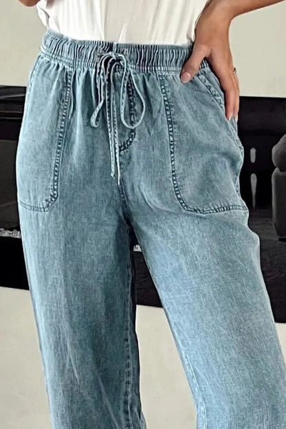 Medium-length drawstring high waist jeans with pockets by Trendsi, featuring a stylish fit and classic denim design.