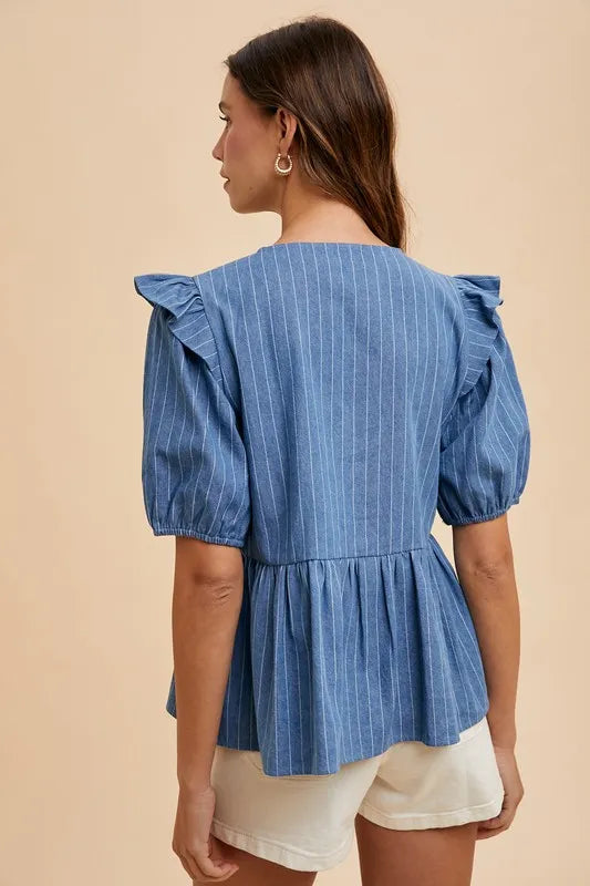 Denim peplum blouse by Annie Wear with stripe front bow, styled with long sleeves and a fitted silhouette.